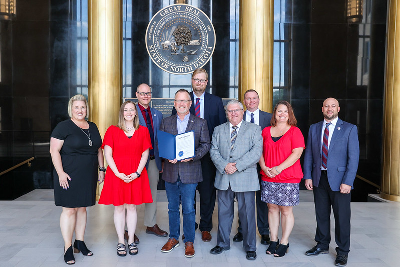 A group of men and women standing in the North Dakota State Capitol